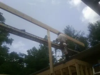 Carpenter setting a ridge beam over a new addition frame — Ice Dam Removal by Roofing Brothers in Polaris