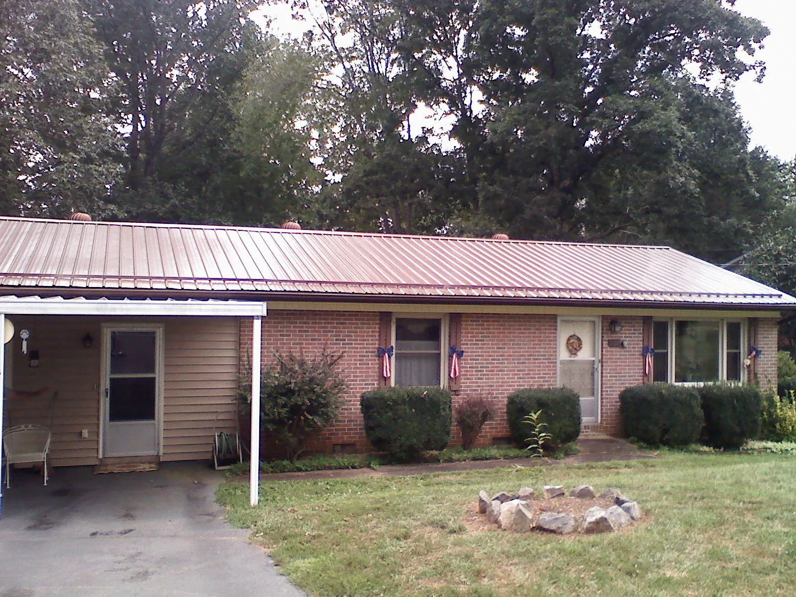Bronze metal roof and carport on a brick ranch home — Roof Repair work by our crew in Polaris